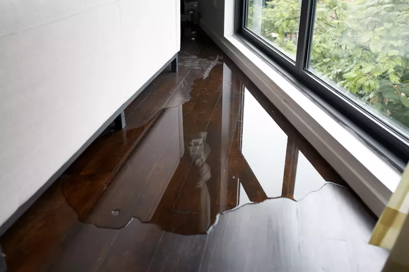 Water leaking and flooded on wood parquet floor. Room floor will damage after the water flooded.