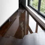 Water leaking and flooded on wood parquet floor. Room floor will damage after the water flooded.